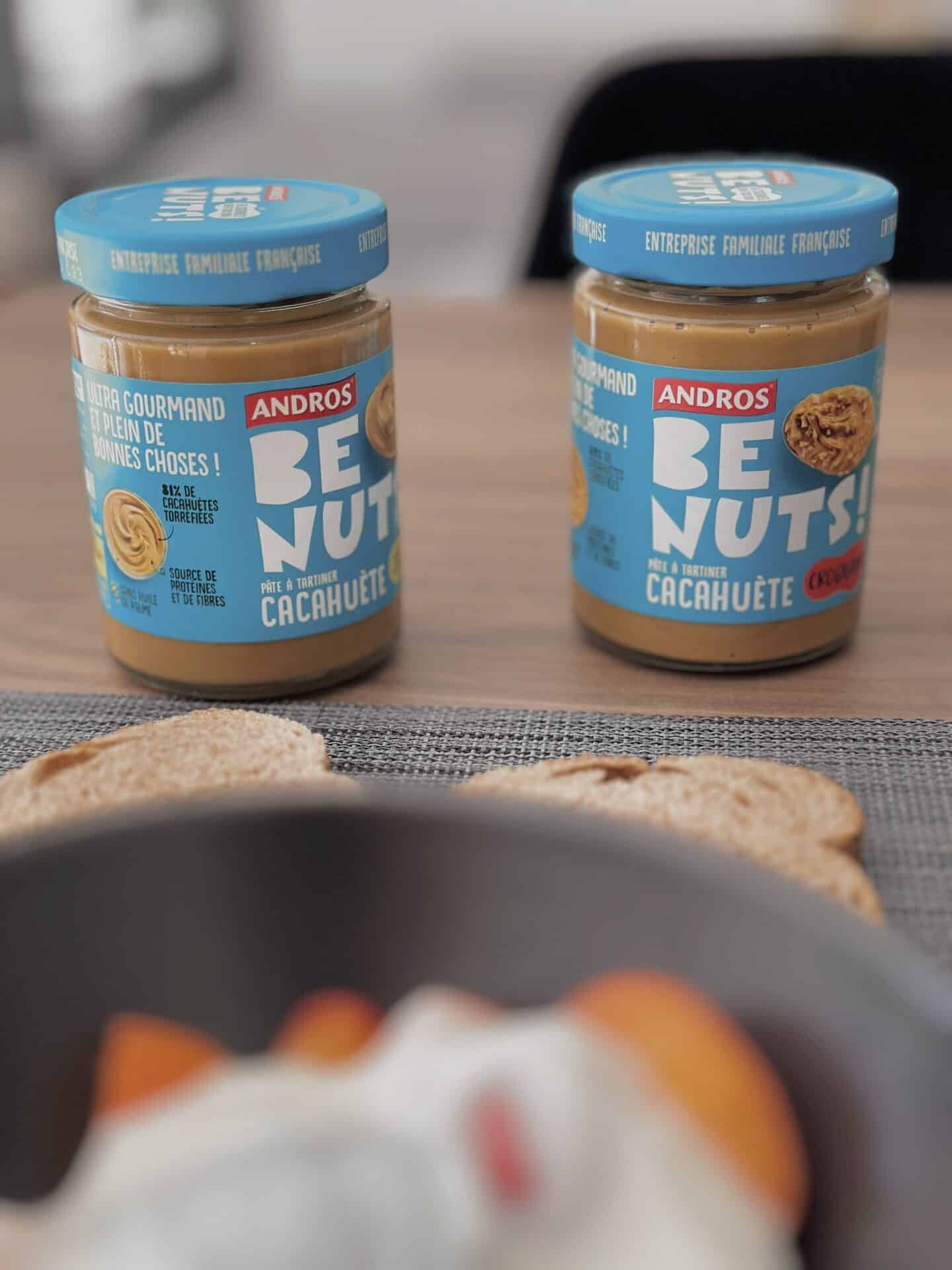 two jars of peanut butter and bread on a table