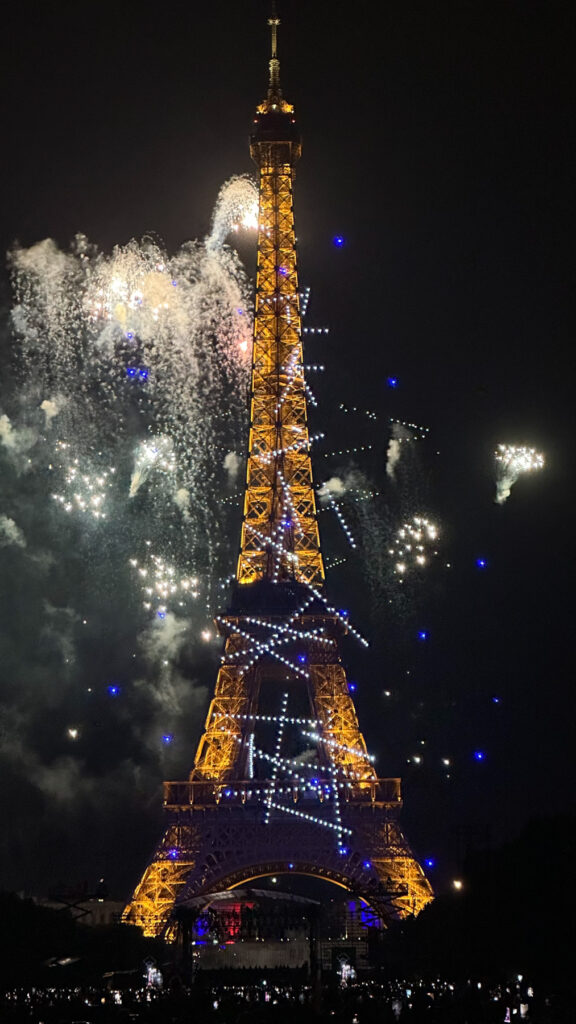 La tour Eiffel illuminée la nuit avec un spectacle de feux d'artifice colorés éclatant dans le ciel sombre autour d'elle