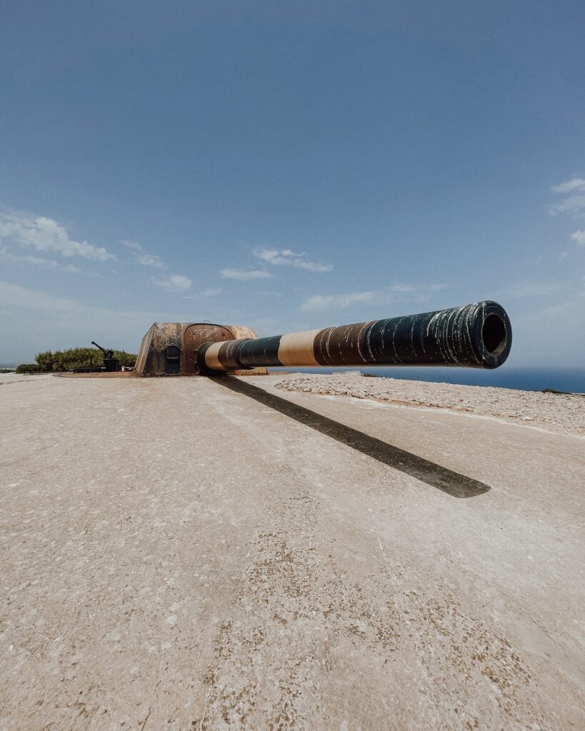 Ancien canon militaire côtier sur une plateforme en béton à Minorque, dominant la mer Méditerranée